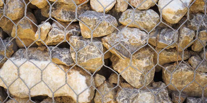 An image of small boulders in wire on a pallet for delivery.