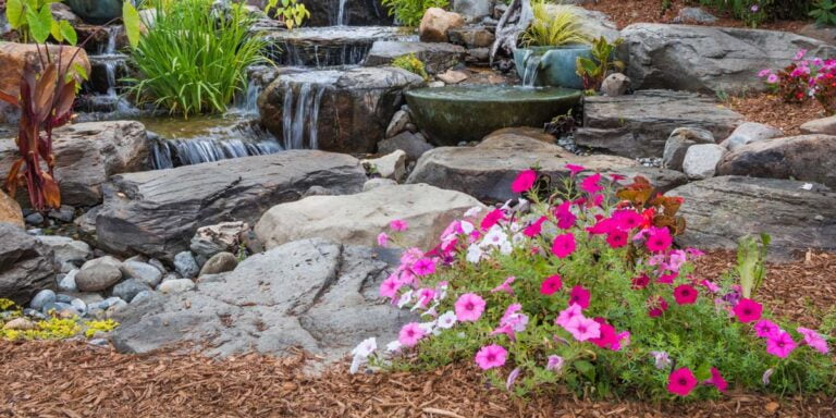 A picture of decorative rocks and boulders used for a water feature in a garden.