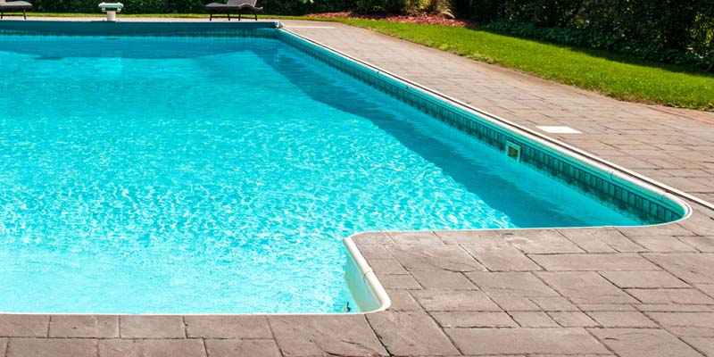 A picture of a pool deck made out of flagstone pavers.
