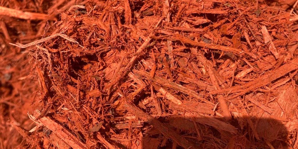 A close up image of ruby red dyed mulch for landscaping in Atlanta.