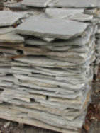 A picture of a stack of thin veneer gray flagstone.