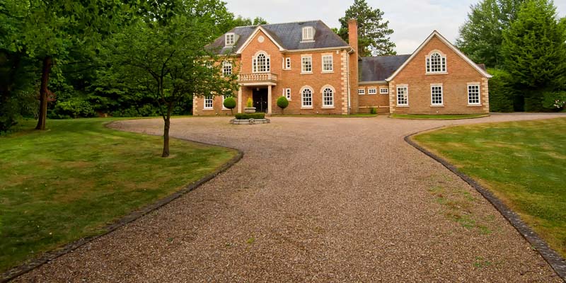 A picture of a home with a gravel driveway.